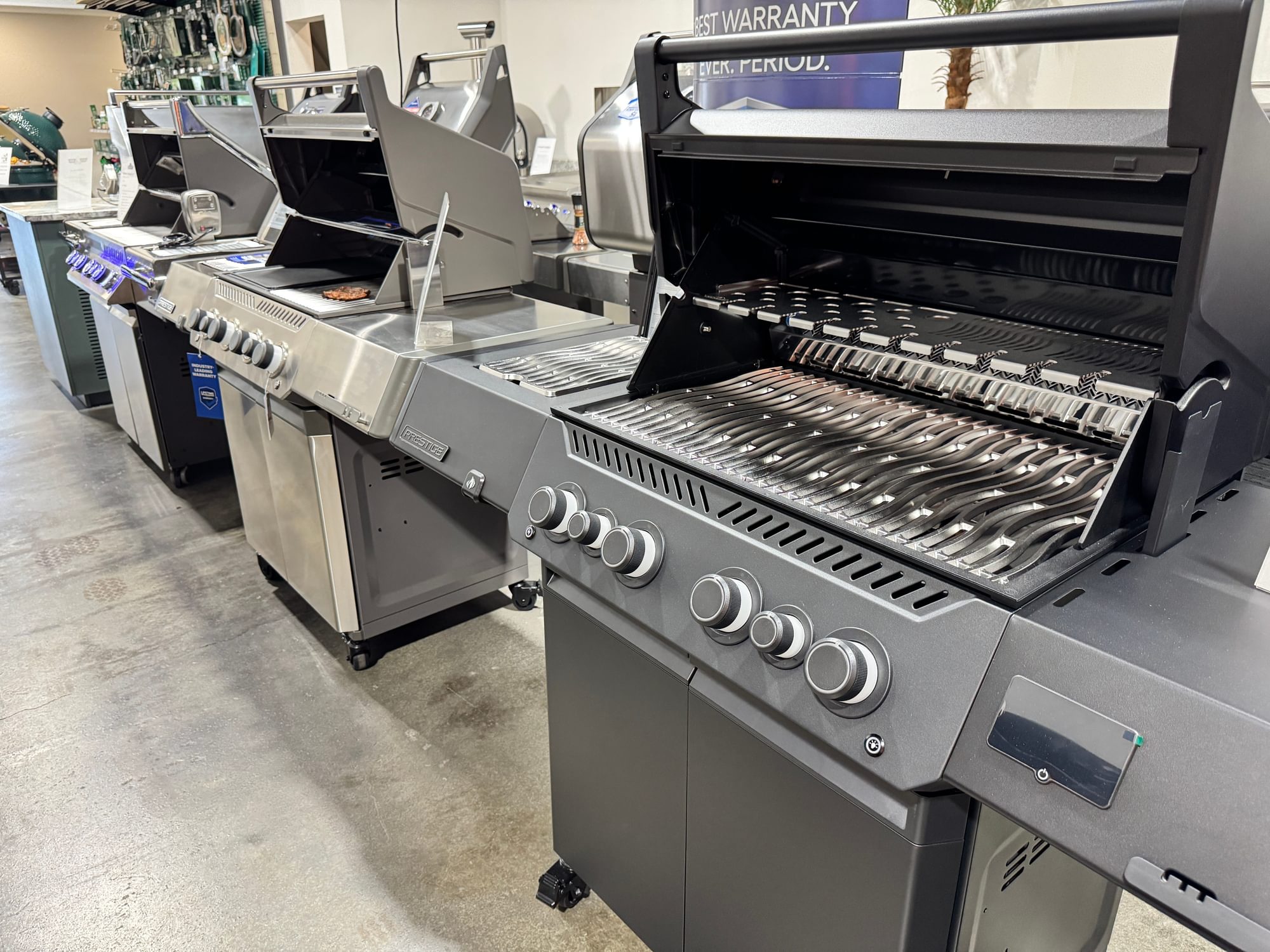 Row of Napoleon cart grills with their lids open.
