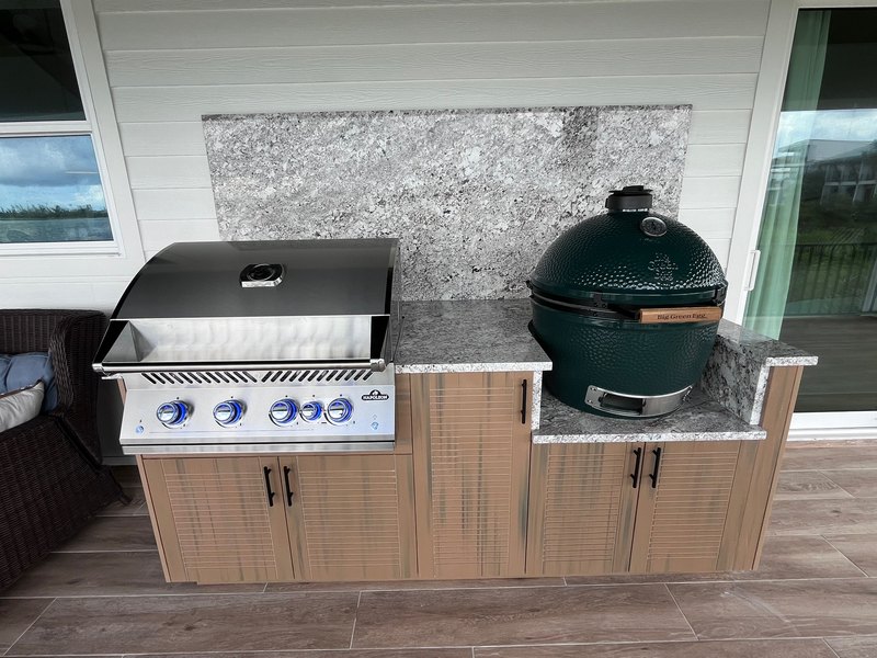 Built-in grill beside a green kamado.